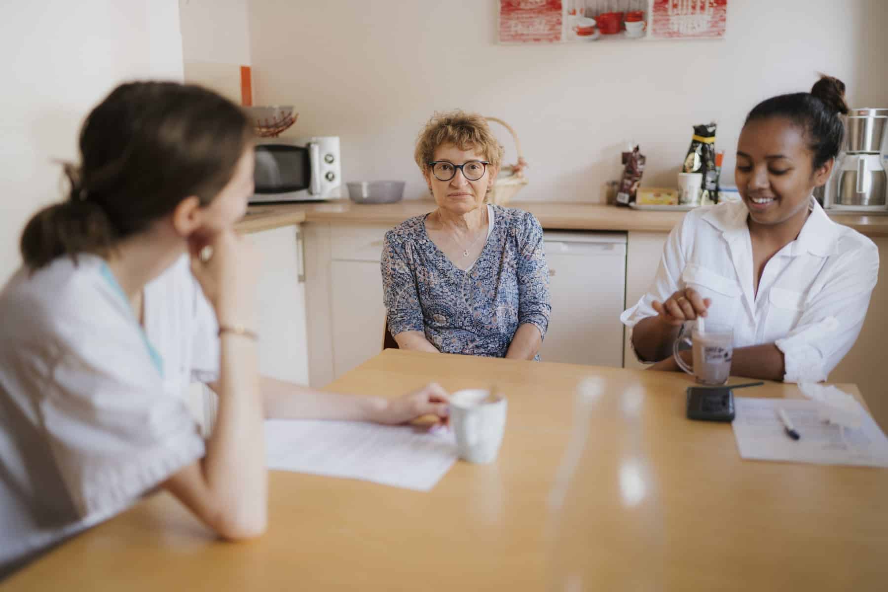 trois personnes qui discutent autour d'une table