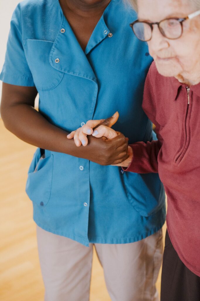 une personne qui aide une femme agée à se tenir debout