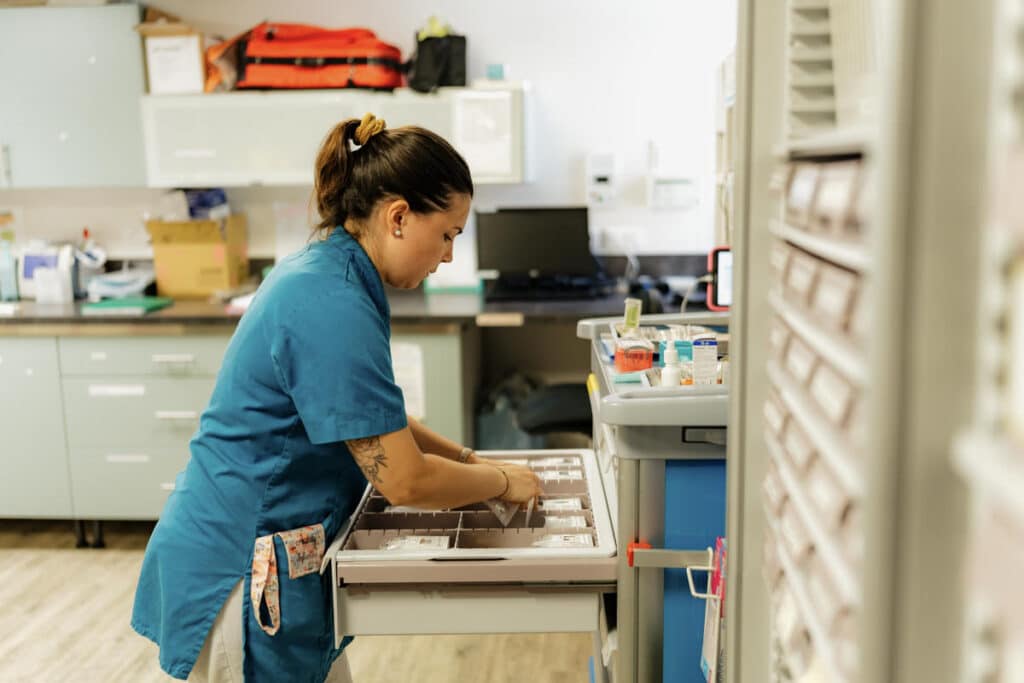 une femme qui cherche des médicaments dans un tiroirs